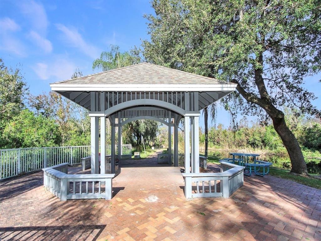 4348 South Kirkman Road, Unit 806 Orlando, FL 32811 - Photo 17 of 29 a view of a patio with a table and chairs under an umbrella with large trees