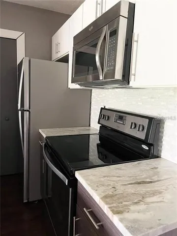 a kitchen with a refrigerator stove and microwave