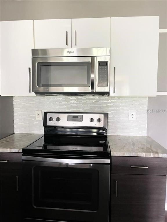 4348 South Kirkman Road, Unit 806 Orlando, FL 32811 - Photo 7 of 29 a stove top oven sitting inside of a kitchen