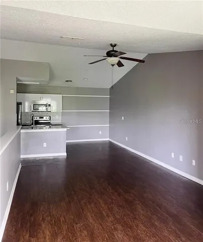 a view of a hallway with wooden floor and chandelier