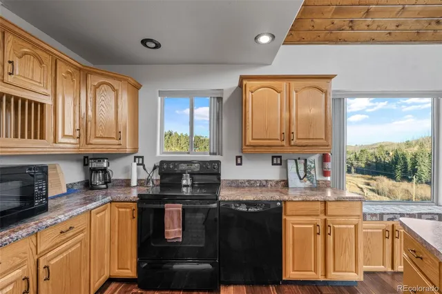 a kitchen with stainless steel appliances granite countertop a stove a sink dishwasher and cabinets with wooden floor