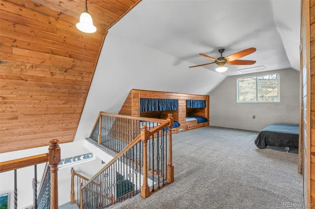 a living room with a bed furniture and a ceiling fan