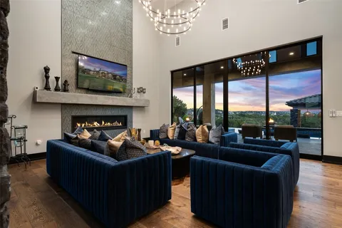a living room with furniture large window and fireplace
