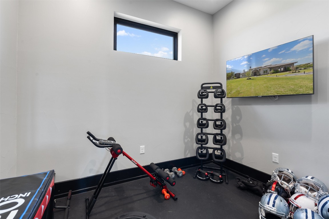 19204 Secretariat Place Spicewood, TX 78669 - Photo 29 of 40 a room with gym equipment and wooden floor