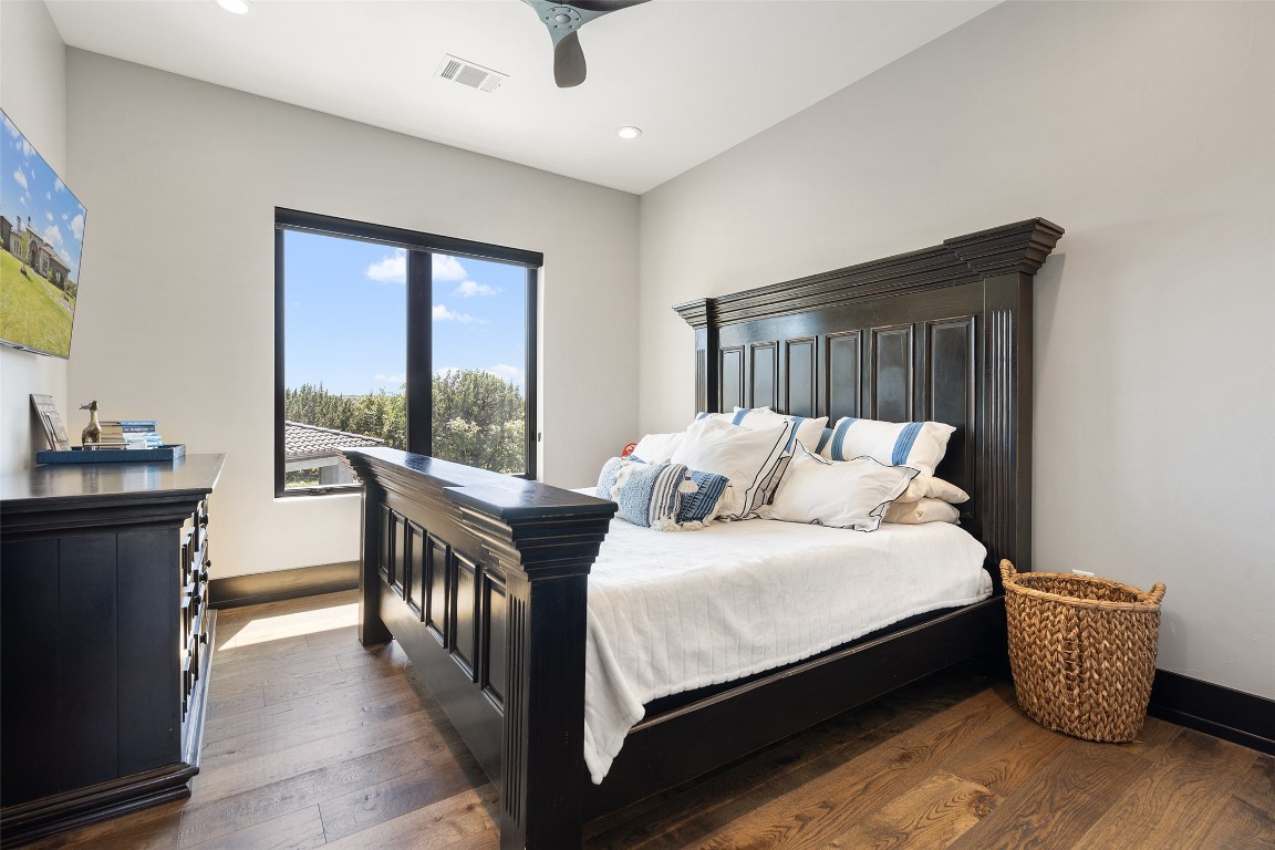 19204 Secretariat Place Spicewood, TX 78669 - Photo 30 of 40 a bedroom with a bed and a large window