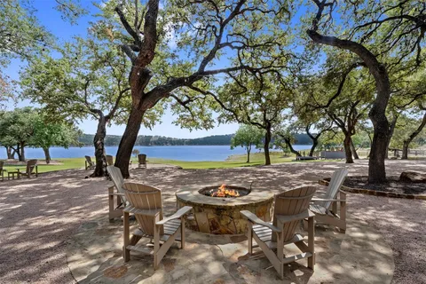 a view of a backyard with table and chairs with a large tree