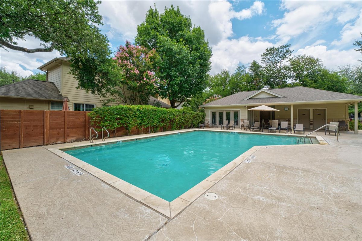 11000 Anderson Mill Road, Unit 11 Austin, TX 78750 - Photo 28 of 34 An inviting outdoor pool with a surrounding patio offers a refreshing escape, bordered by lush greenery and a charming pool house.