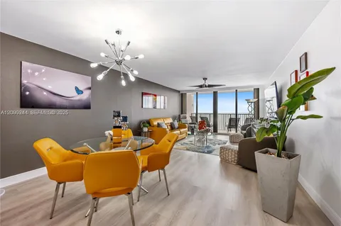 a living room with furniture a chandelier and a potted plant