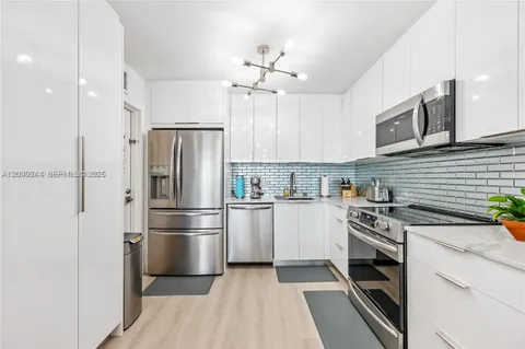 a kitchen with cabinets stainless steel appliances and a window