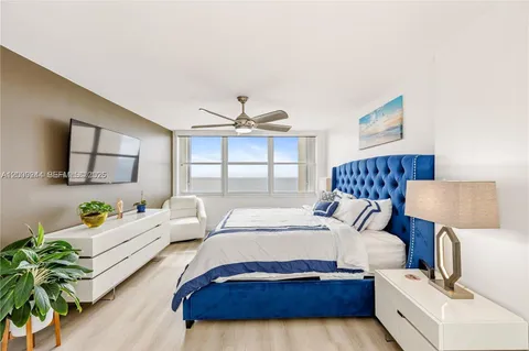 a bedroom with a bed lamp and a potted plant