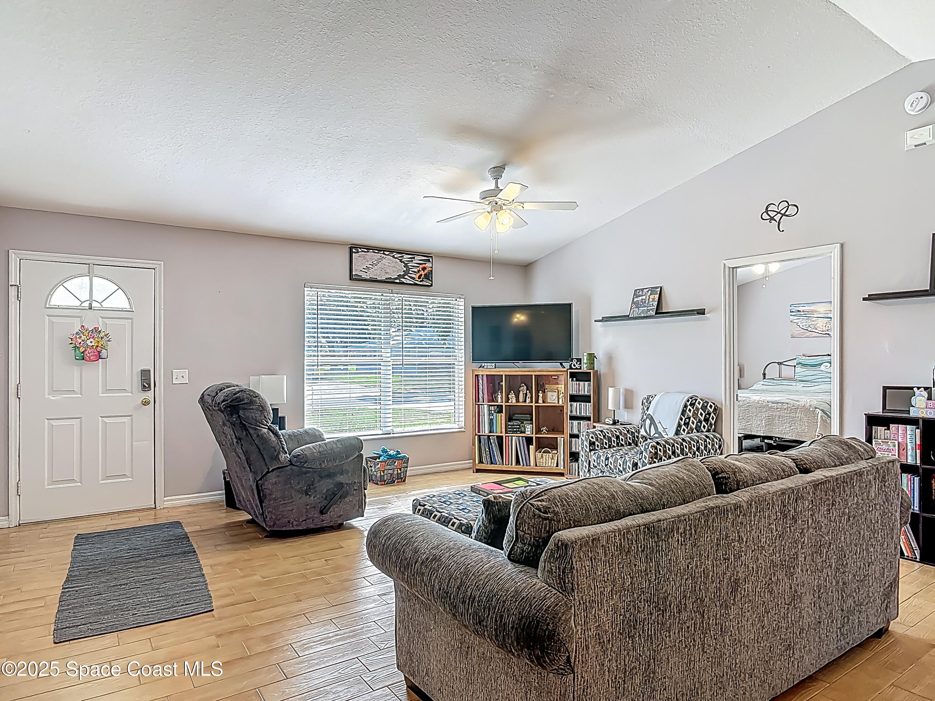 3104 Lime Tree Drive Edgewater, FL 32141 - Photo 12 of 32 a living room with furniture a ceiling fan and a window