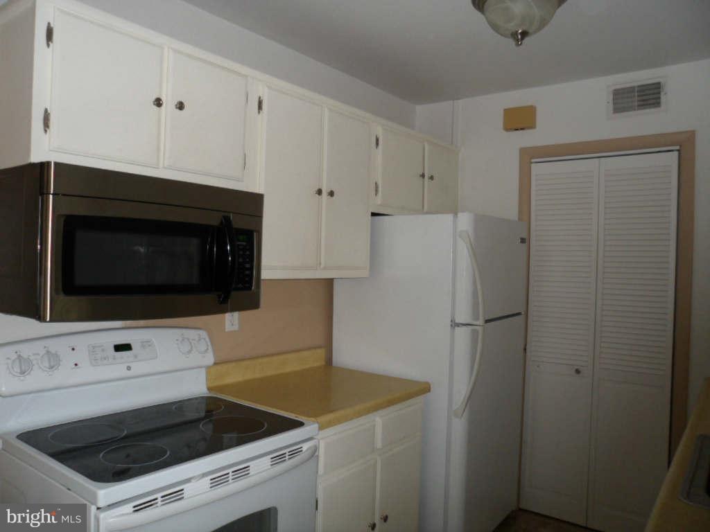 84 Ridgelawn Road, Unit B Reisterstown, MD 21136 - Photo 8 of 17 a kitchen with white cabinets and white appliances