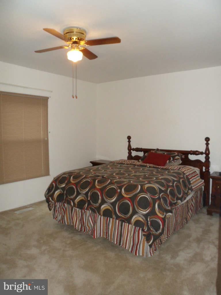 84 Ridgelawn Road, Unit B Reisterstown, MD 21136 - Photo 10 of 17 a bedroom with a bed and a chandelier