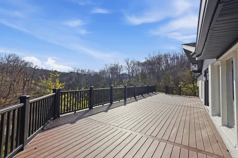 a view of a house with wooden deck and furniture