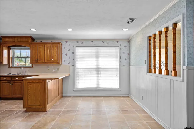 a large kitchen with stainless steel appliances granite countertop a sink and a large window