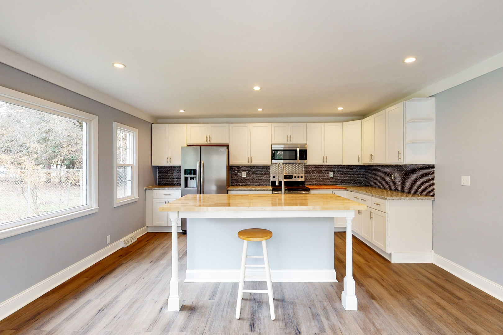 538 Russell Road DeKalb, IL 60115 - Photo 5 of 35 a kitchen with stainless steel appliances granite countertop a stove a refrigerator a white table and chairs with wooden floor