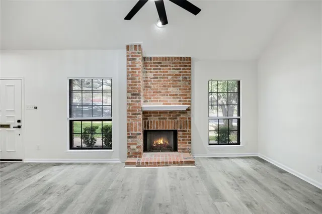 wooden floor fireplace and window in an empty room