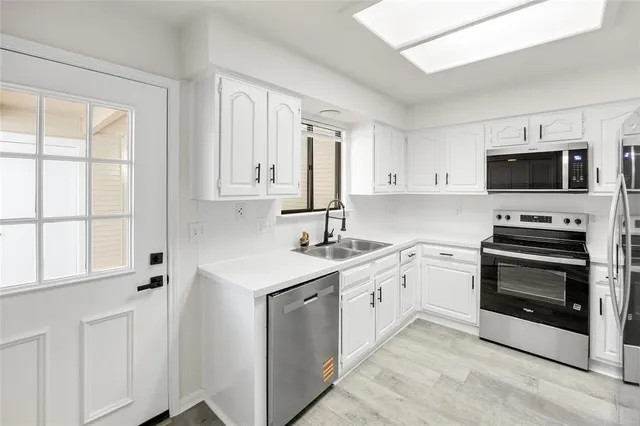 a kitchen with stainless steel appliances a stove sink and microwave