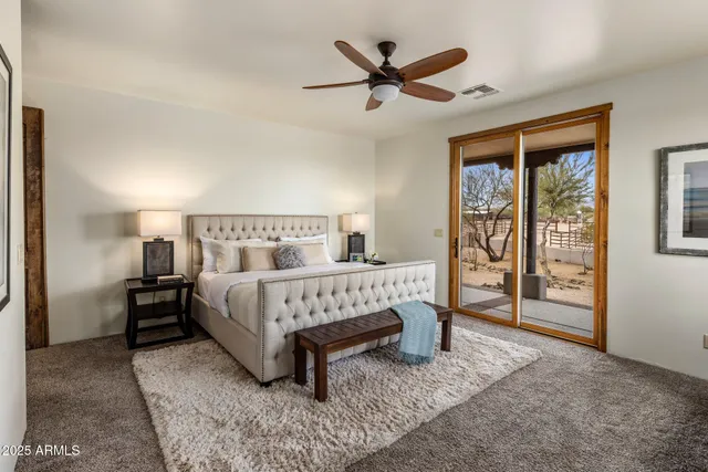 a bed sitting in a spacious bedroom next to a window
