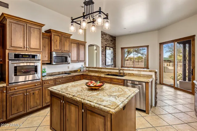 a kitchen with granite countertop stove top oven microwave and cabinets