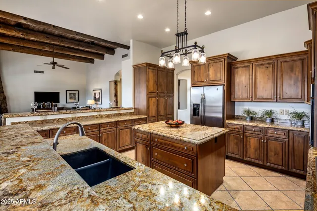 a kitchen with stainless steel appliances granite countertop a stove a sink and a refrigerator