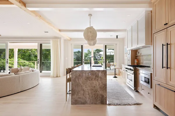 a living room with furniture large windows and flat screen tv