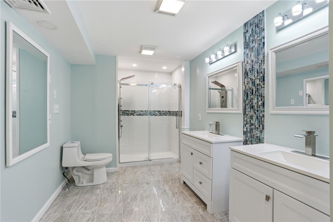 6271 Batman Road Zionsville, PA 18092 - Photo 52 of 100 A well-lit primary bathroom features dual vanities, a spacious shower, and elegant tile flooring.