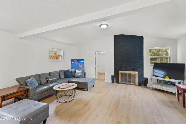 a living room with furniture a flat screen tv and a table