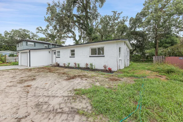 a view of a backyard with large trees
