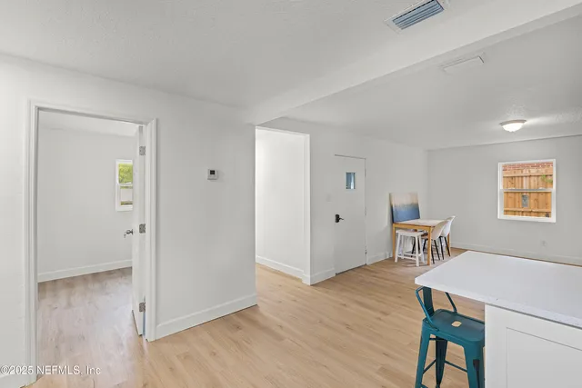 a view of a room with wooden floor lounge chair and windows