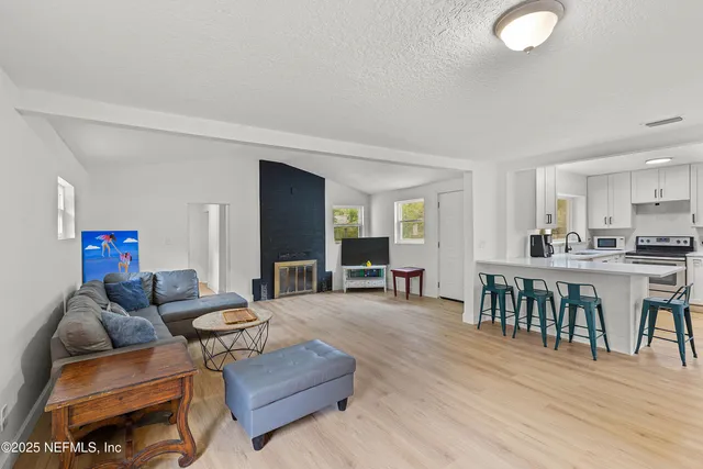 a living room with furniture a wooden floor and a sink