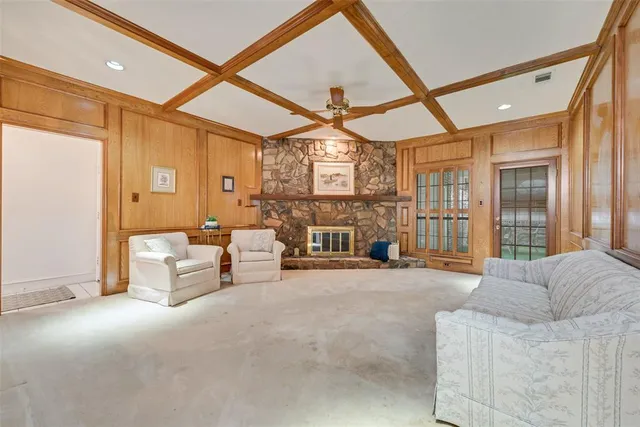 a living room with furniture a ceiling fan a rug and a window