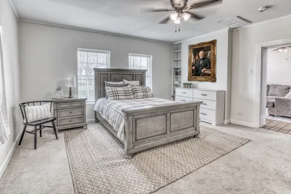 a bed sitting in a room next to a lamp and a chandelier