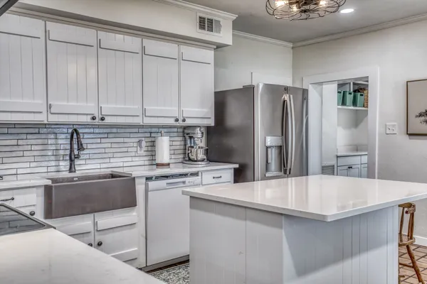 a kitchen with kitchen island stainless steel appliances a sink stove and refrigerator