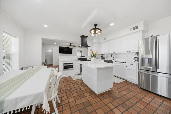 a spacious bedroom with a bed a dresser and next to a window