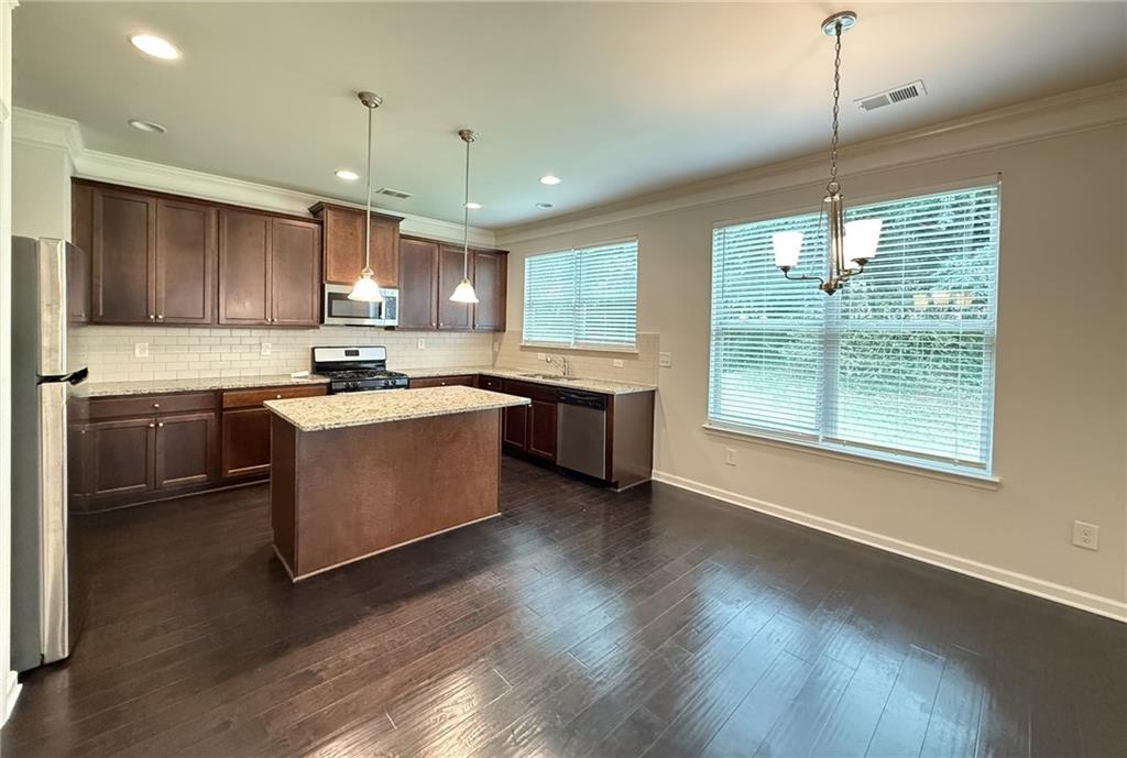 2467 Overlook Avenue Lithonia, GA 30058 - Photo 27 of 51 a kitchen with kitchen island a sink stainless steel appliances and cabinets