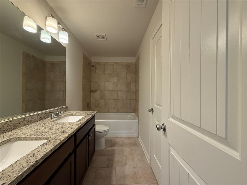 2467 Overlook Avenue Lithonia, GA 30058 - Photo 48 of 51 a bathroom with a granite countertop sink a toilet and bathtub
