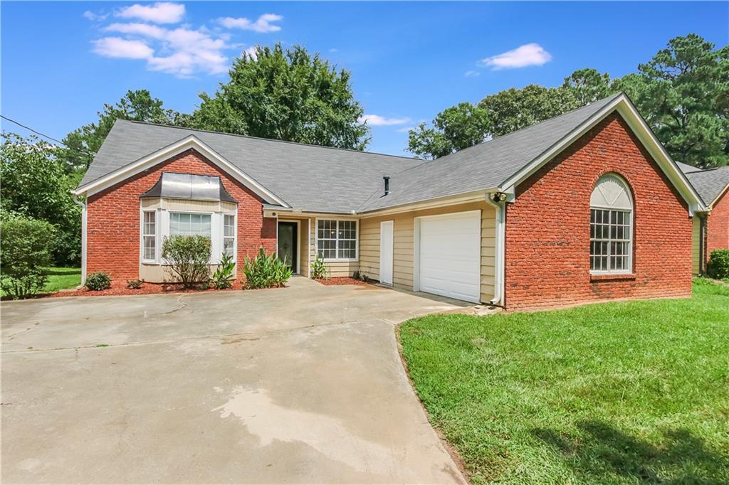 5692 Salem Road Lithonia, GA 30038 - Photo 1 of 1 a front view of a house with a garden and trees
