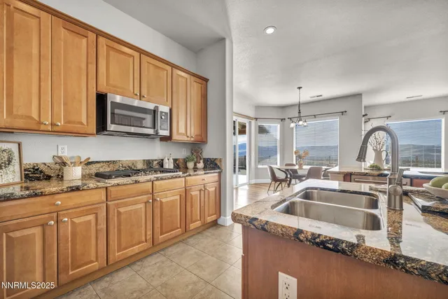 a kitchen with stainless steel appliances granite countertop a stove a sink a refrigerator and island