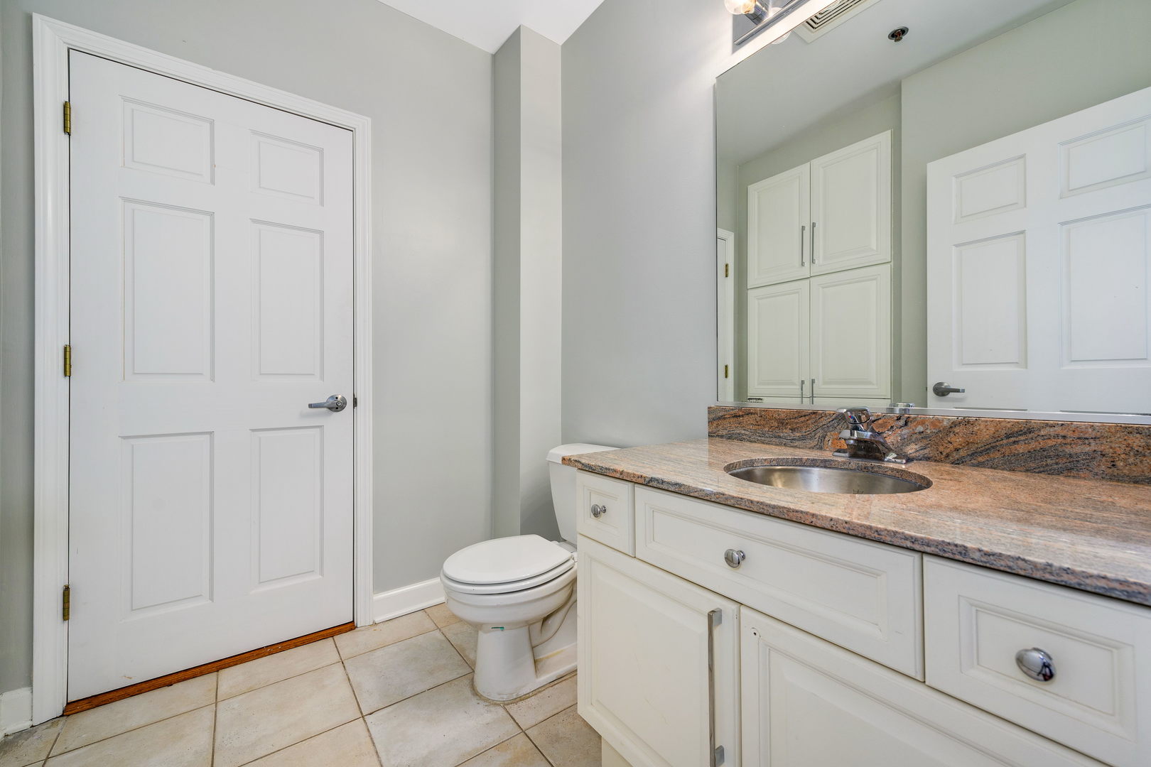 1301 West Madison Street, Unit 520 Chicago, IL 60607 - Photo 15 of 17 a bathroom with a granite countertop toilet sink and mirror