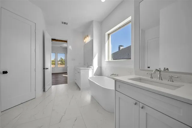 a spacious bathroom with a sink and a mirror