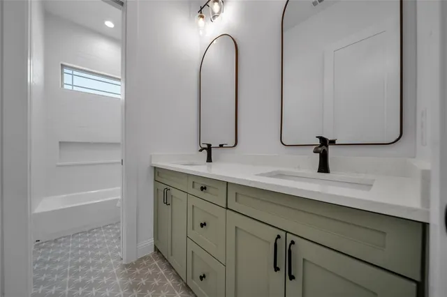 a bathroom with a double vanity sink and a mirror