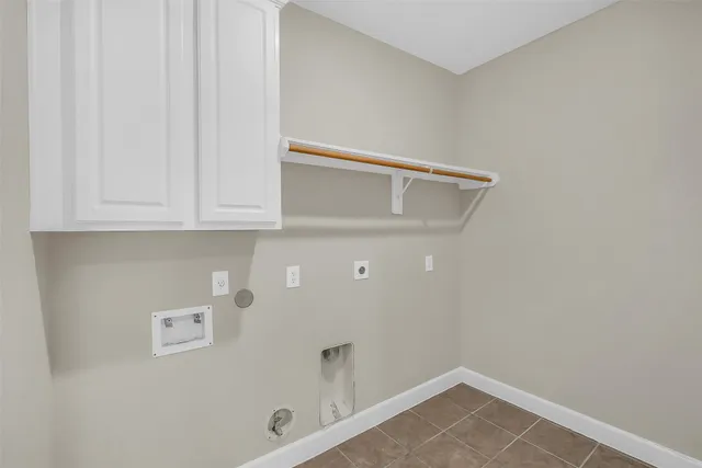 an empty room with wooden floor chandelier and windows