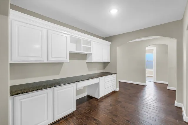 an empty room with wooden floor and window