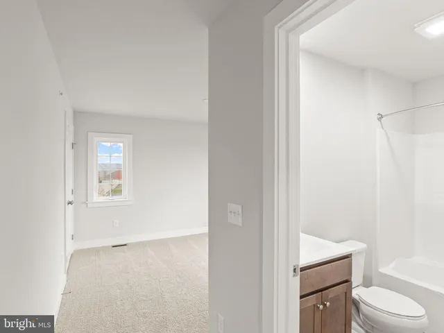 a bathroom with a toilet sink vanity tub and shower