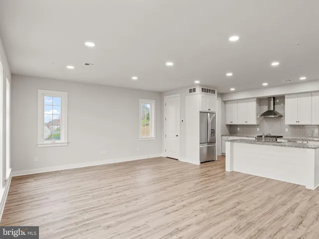 a open kitchen with kitchen island a sink dishwasher a stove and a refrigerator with wooden floor