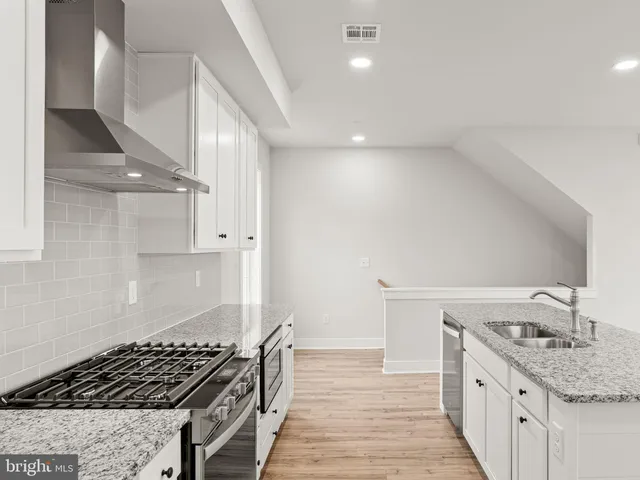 a kitchen with granite countertop a stove and a sink