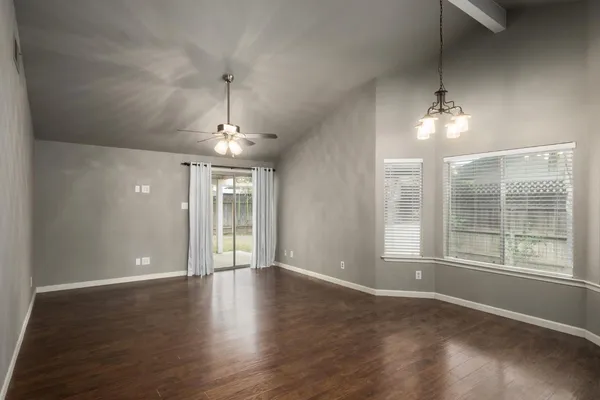 a view of an empty room with glass door and windows
