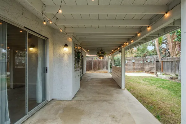 a view of a hallway with wooden floor and chandelier