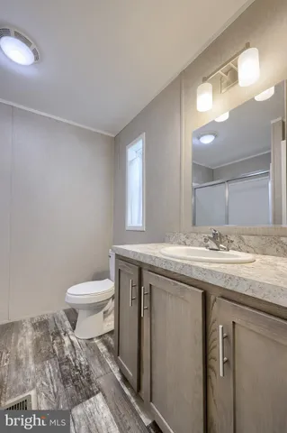 a bathroom with a granite countertop sink a toilet and a mirror